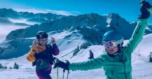 Das Foto zeigt zwei lachende Skifahrerinnen bei tollem Wetter auf einer Piste als Sinnbild für den Wintersport ohne körperliche Beschwerden