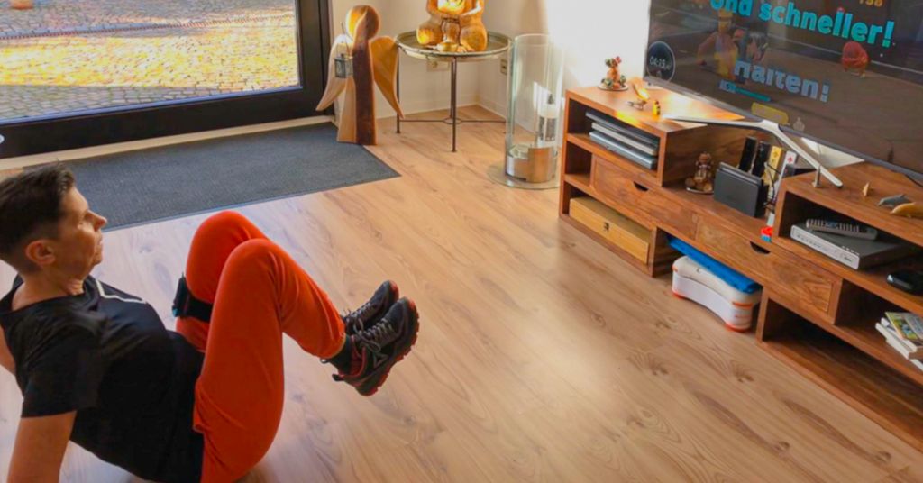 Das Foto zeigt die Autorin beim Training im Wohnzimmer vor dem Fernseher mit einem Bewegungsspiel für die Spielekonsole