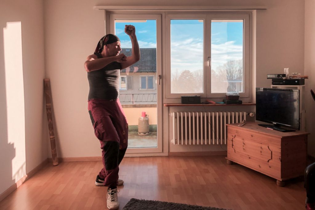 Das Foto zeigt den Autor bei Sportübungen vor dem Fernseher im Wohnzimmer als Sinnbild für mehr Aktivität im Alltag durch Bewegungsspiele