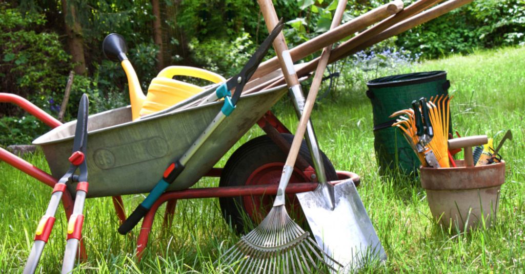 Das Bild zeigt eine Schubkarre mit verschiedenen Gartengeräten als Sinnbild für die Gartenarbeit als gesunde Bewegung