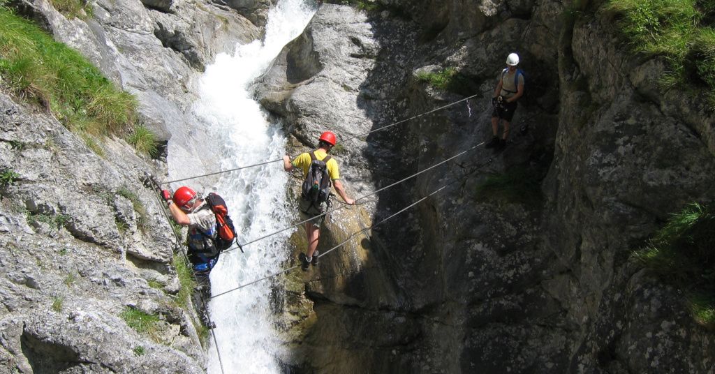 Das Bild zeigt Personen auf einer Seilbrücke hier im Beitrag Klettersteige