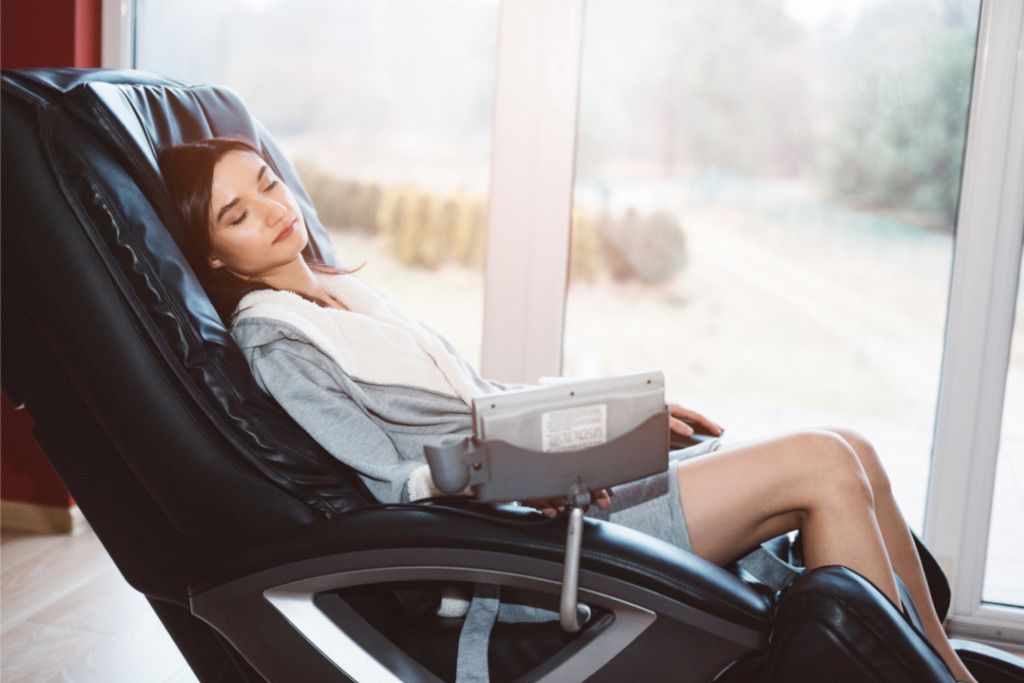 Das Bild zeigt eine entspannte Frau bei der Massage in einem guten Massagesessel mit der richtigen Ausstattung.