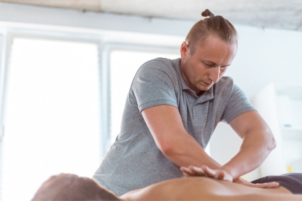 Das Bild zeigt einen Physiotherapeuten als Beispiel für den Fachmann bei der professionellen Massage im Rückenbereich.