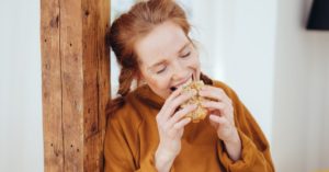 Das Foto zeigt eine Frau beim emotionalen Essen als Beispiel dafür wie die Progressive Muskelentspannung gegen Stressessen helfen kann