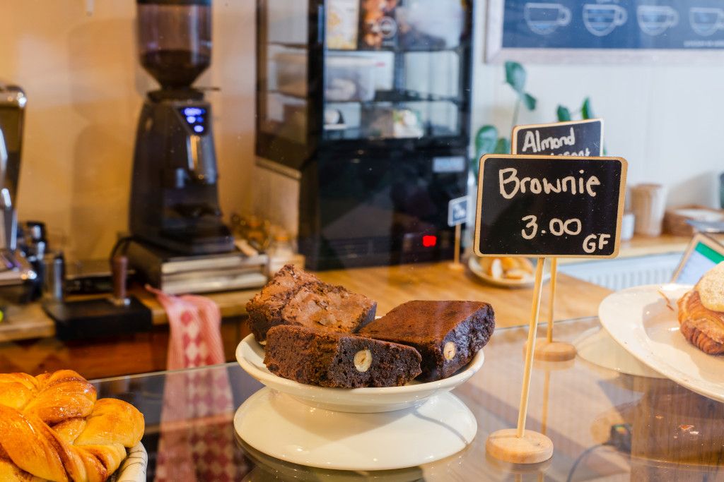 Das Bild zeigt eine Verkaufstheke mit einem Teller Brownies als Beispiel ungesunder aber wohlschmeckender Lebensmitteln aus dem Online-Präventionskurs zur Ernährung