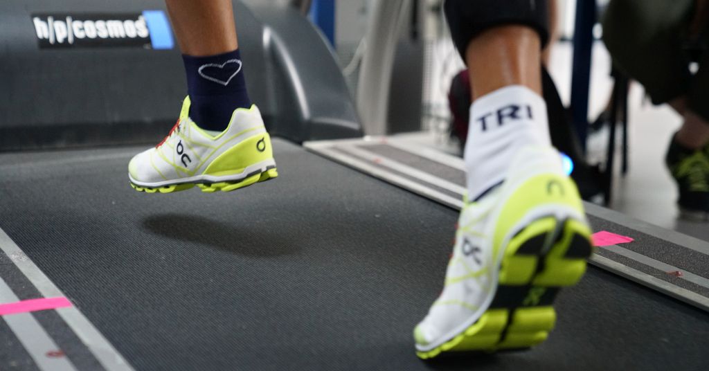 Das Bild zeigt die Füße eines Läufers mit Turnschuhen auf einem Laufband bei der Analyse der Leistungssteigerung durch High-Tech im Laufschuh