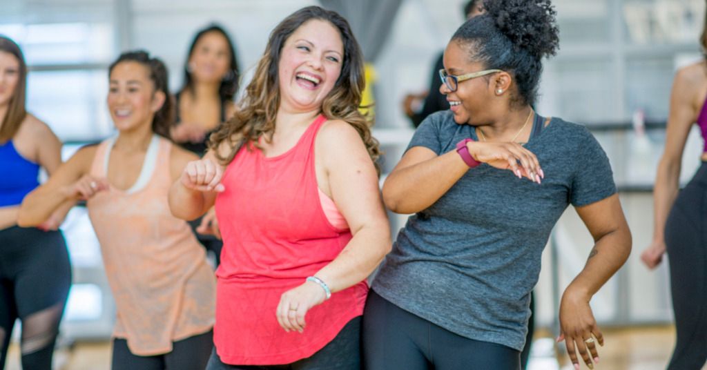 Das Foto zeigt eine Gruppe von lachenden Frauen beim gemeinsamen Sport als Sinnbild für die Bedeutung das richtige Fitnessstudio zu suchen