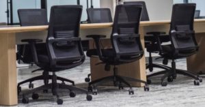Das Bild zeigt eine Reihe von ergonomischen Bürostühlen in einem Büro als Sinnbild für die Entlastung des Körpers mit einstellbarem Bürostuhl oder Gaming-Stuhl