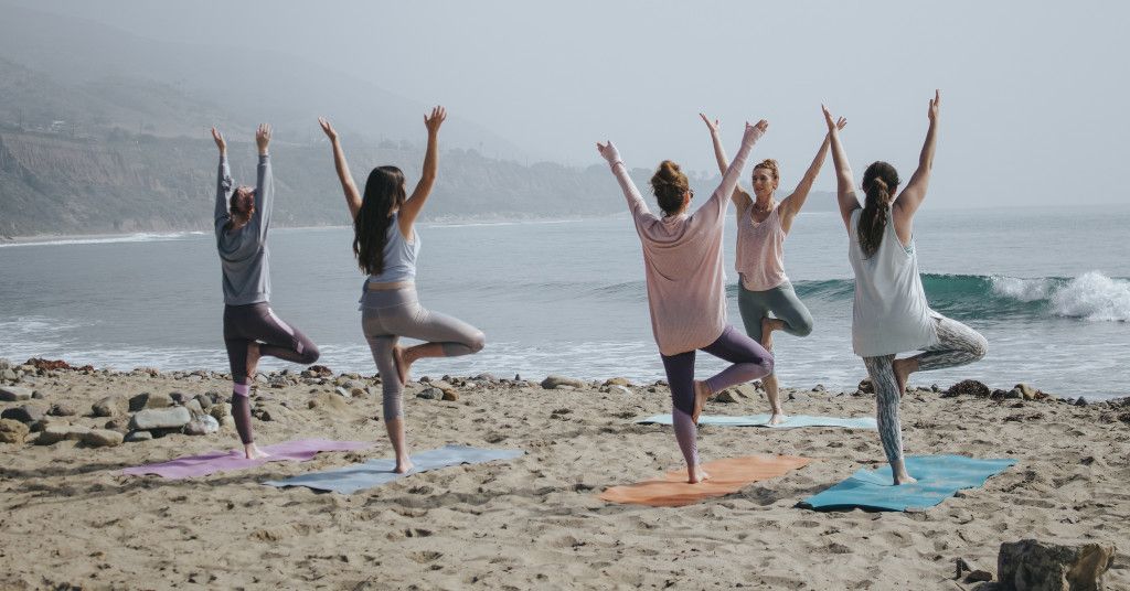 Das Bild zeigte einen Fitness Lehrer mit einer Gruppe am Strand als Sinnbild für den Einsatz einer Fitness DVD für dein Training zuhause