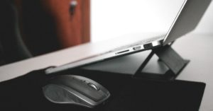 Das Bild zeigt einen Laptop auf einem Ständer als Sinnbild für einen ergonomischen Arbeitsplatz mit dem richtigen Laptop-Ständer