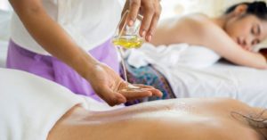 Das Bild zeigt einen Masseur der sich ein Massageöl in die Hände gießt als Sinnbild für das Thema richtiges Massagezubehör