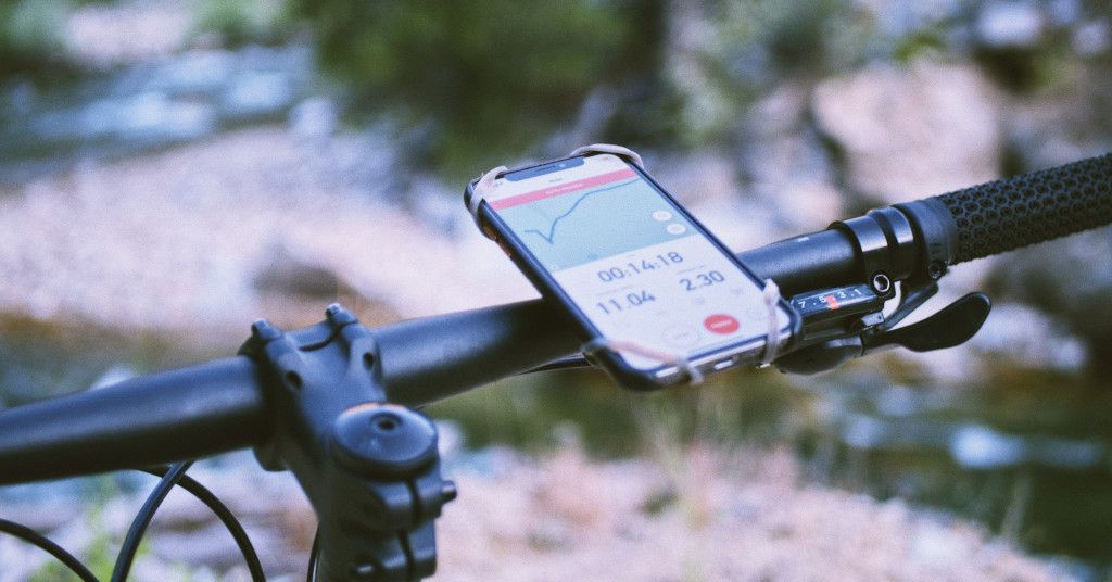 Das Bild zeigt ein Smartphone mit Routenplan an einem Fahrradlenker als Sinnbild für gute Trainings-Apps die deinen Sport unterstützen und dich motivieren