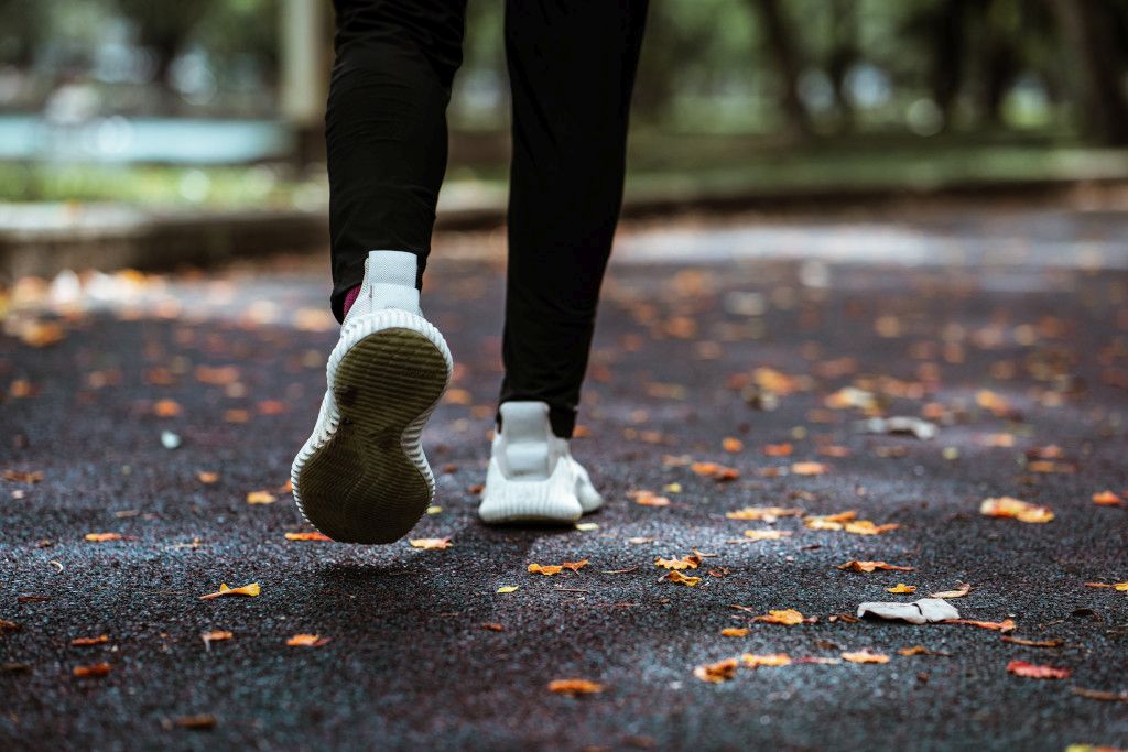Das Bild zeigt die Füße eines Menschen beim Walken als Sinnbild für den Beitrag der Bewegung bei der Stressbewältigung und um Stress abbauen zu können