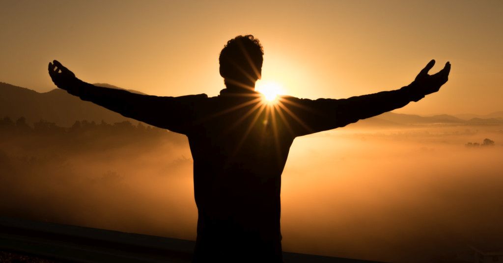 Das Bild zeigt einen Menschen mit ausgebreiteten Armen vor einem Sonnenaufgang als Sinnbild für die Freude nach dem erfolgreichen Rauchstopp mit dem Rauchfrei Programm welches es auch online gibt