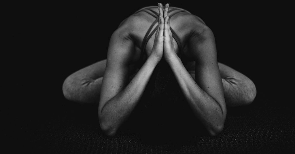 Das Bild zeigt einen Menschen bei einer abendlichen ruhigen Yoga-Übung als Sinnbild für ein abendliches zur Ruhe kommen mit Yoga