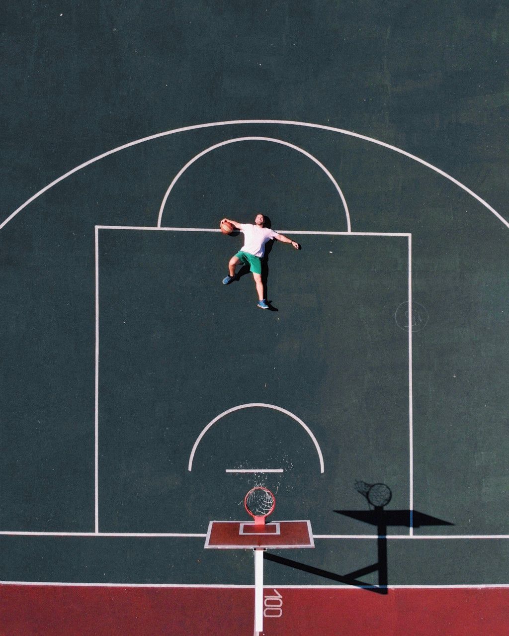 Das Bild zeigt einen erschöpften Basketballer der auf dem Court liegt als Sinnbild für den Motivationsverlust beim Übertrainingssyndrom