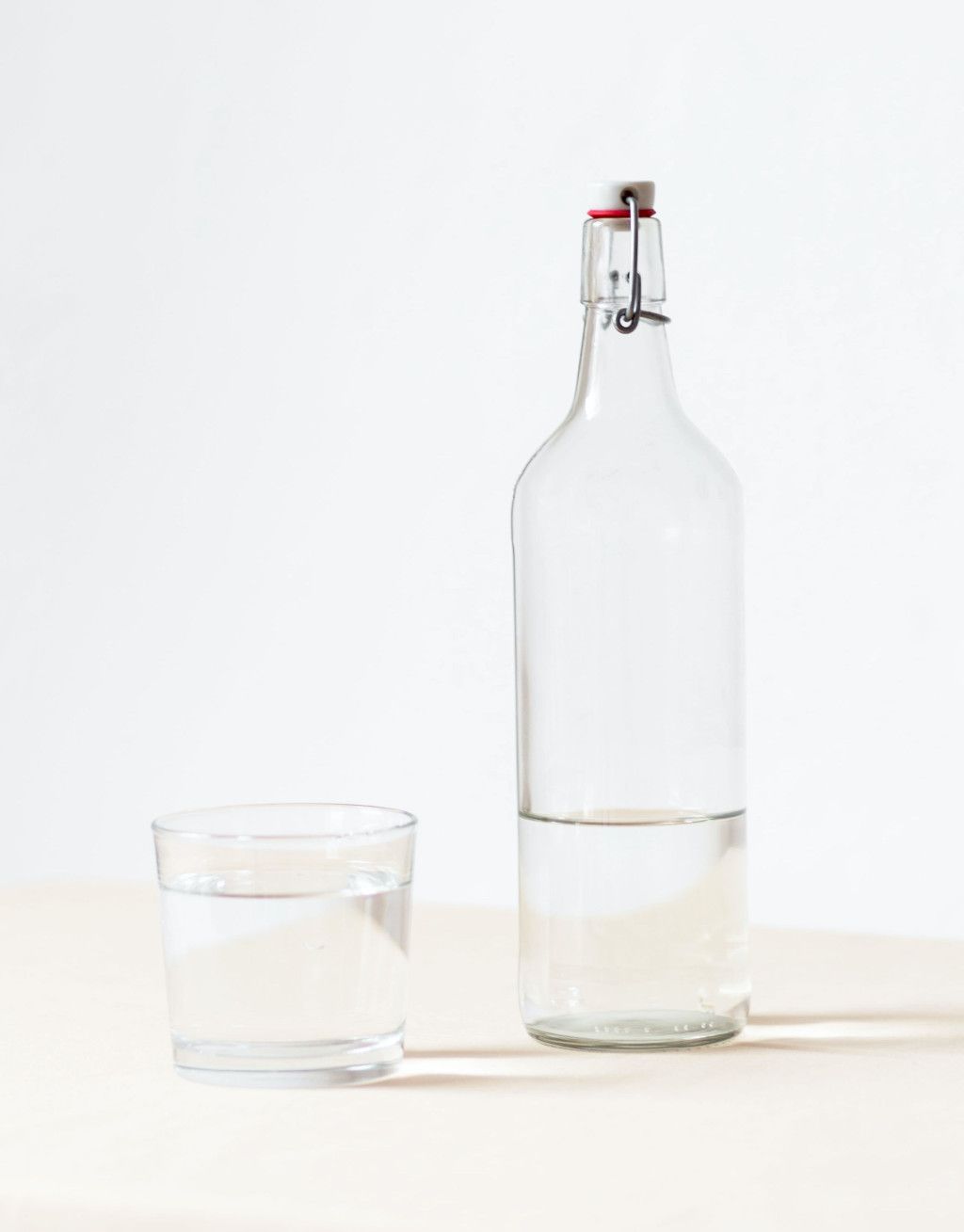 Das Bild zeigt eine Flasche und ein Trinkglas mit hochwertigem Wasser als Sinnbild für die Bedeutung vom Trinken auf deinem Abnehm-Weg