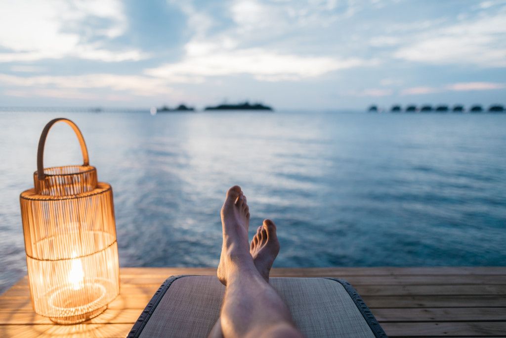 Das Bild zeigt einen Menschen bei der Entspannung am abendlichen Strand als Sinnbild für die Bedeutung der Fantasie zur Erholung vom Alltag