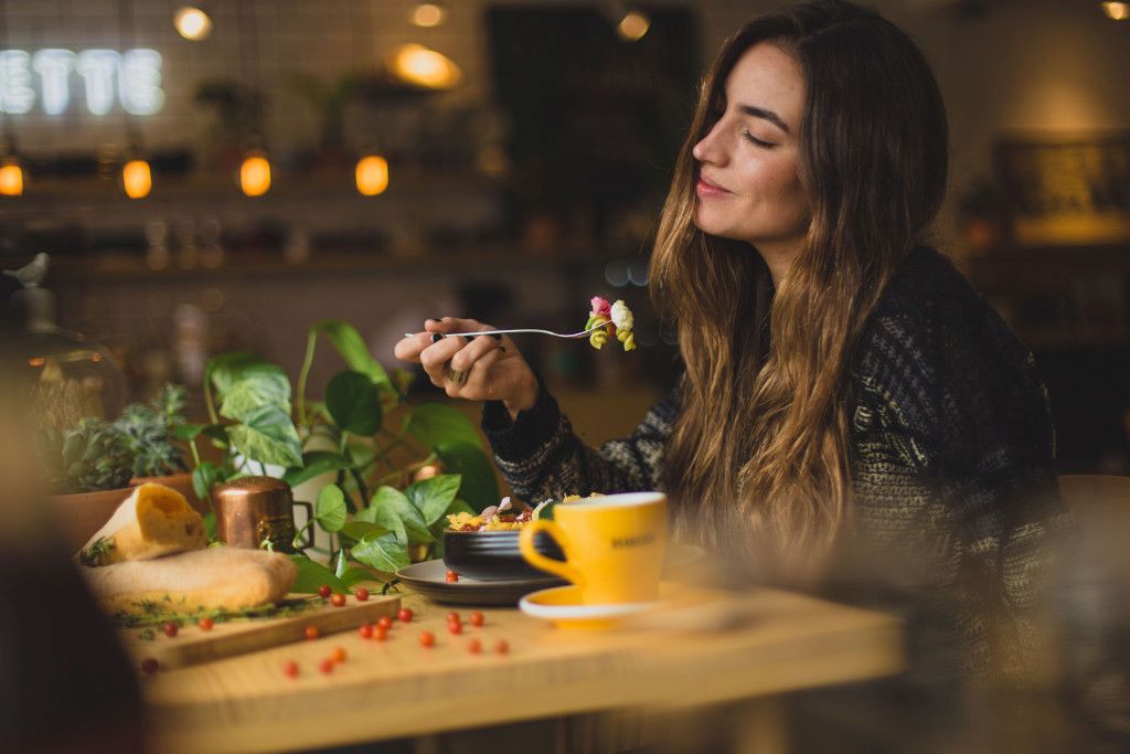 Das Bild zeigt eine Frau beim genussvollen Essen als Sinnbild für die Bedeutung der Achtsamkeit auf deinem Abnehm-Weg