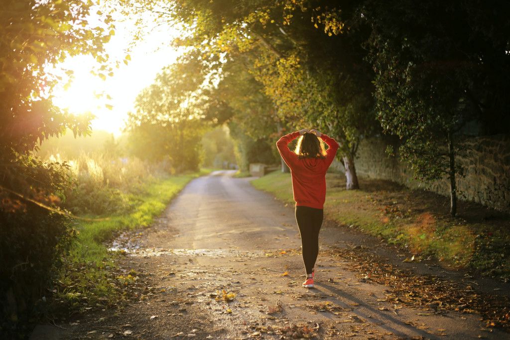Das Bild zeigt einen Menschen auf einer sonnigen Landstraße als Sinnbild für die vielfältigen Möglichkeiten zur Bewegung und zum Sport draußen in der Natur auf deinem Abnehm-Weg