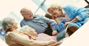 Das Bild zeigt eine Gruppe von strahlenden älteren Menschen im angeregten Gespräch als Sinnbild für die vielen Vorteile einer Tagespflege für Seniorinnen und Senioren.