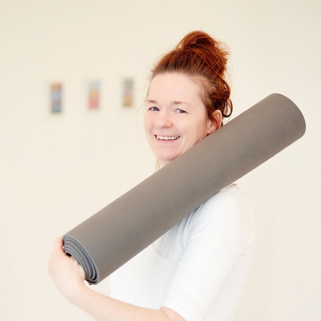 Das Bild zeigt eine strahlende Yogalehrerin als Sinnbild für den wertvollen Beitrag von Yogalehrenden zur Stärkung der Gesundheit.