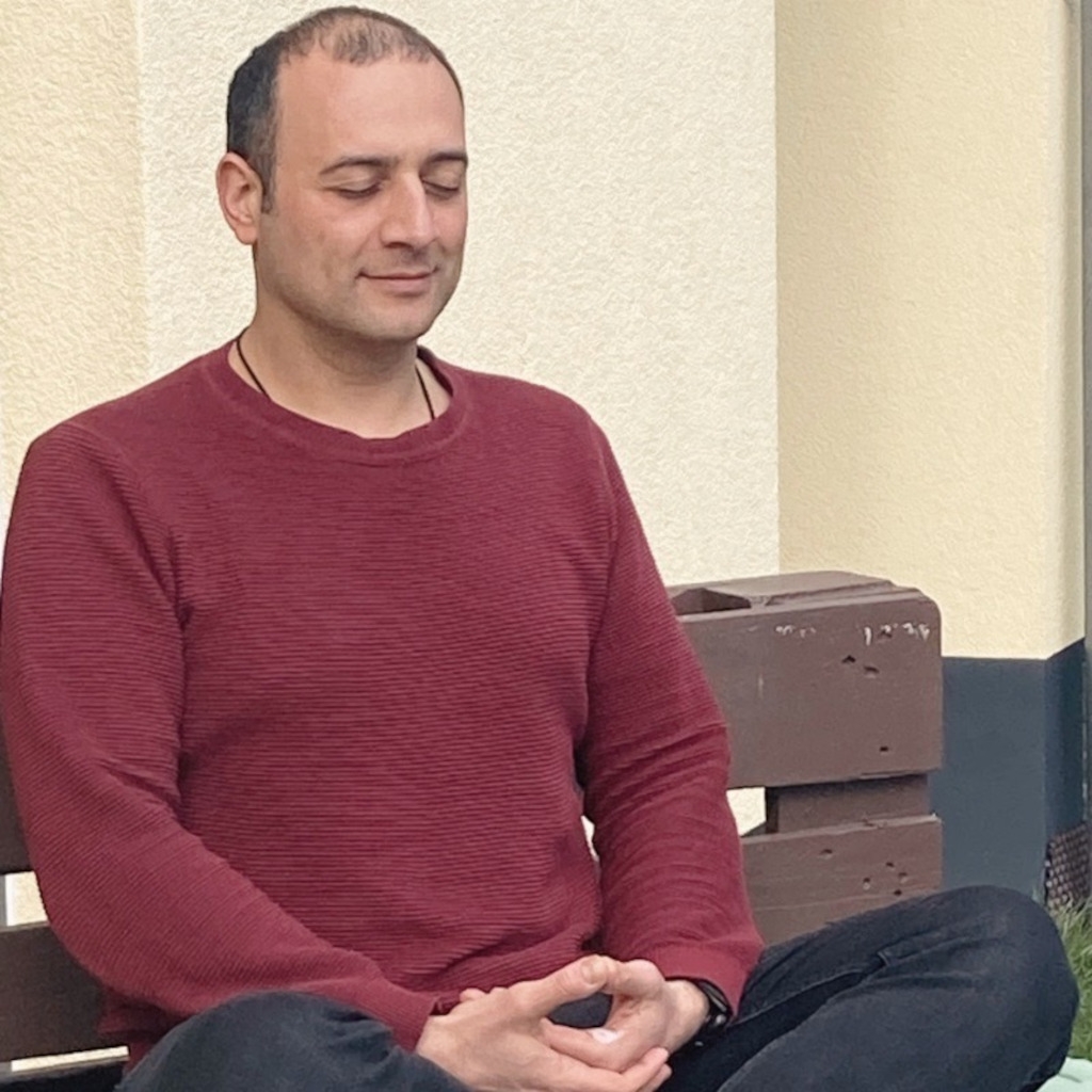 Das Bild zeigt den Physiotherapeuten und Osteopathen Giuseppe Randisi bei der Meditation als Sinnbild für die Bedeutung der Entspannung bei der osteopathischen Behandlung gegen stressbedingte Rückenschmerzen.
