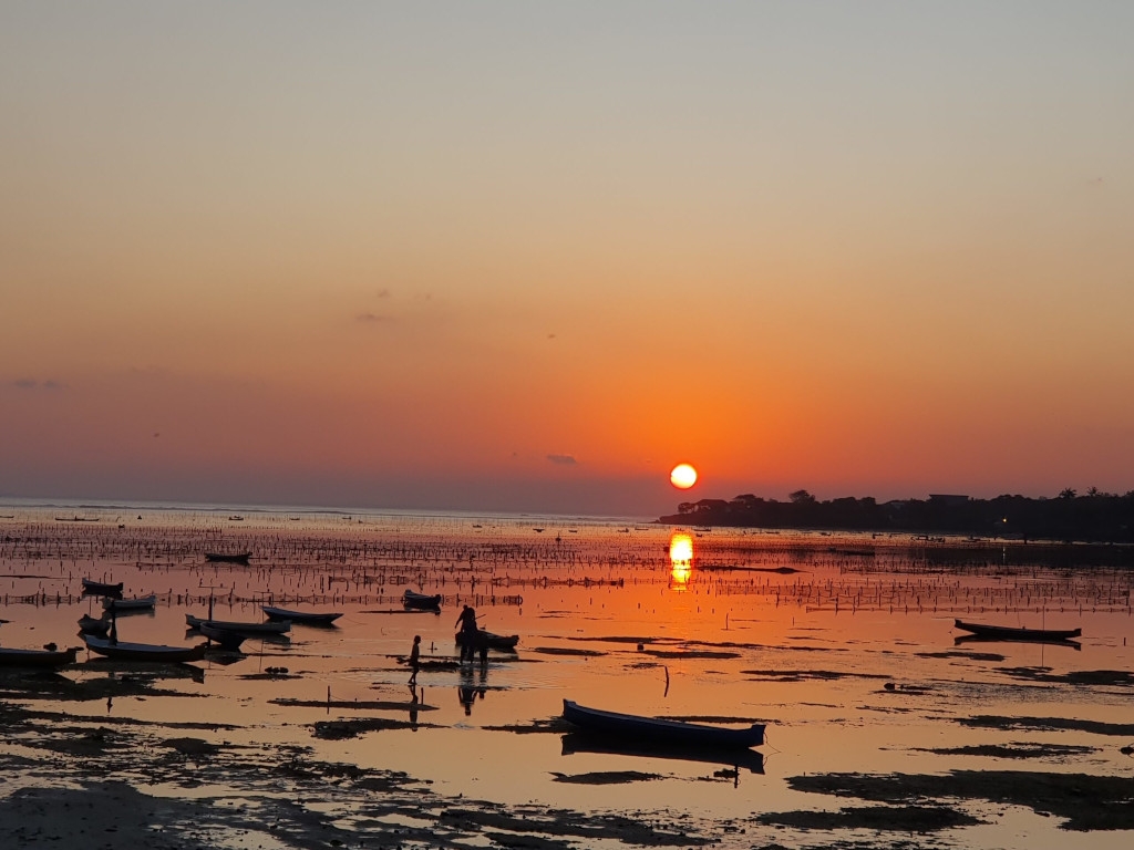 Das Bild zeigt eine mit knöcheltiefem Wasser überflutete Landschaft im Sonnenuntergang als Sinnbild für die unterschiedlichen klimatischen und hygienischen Bedingungen in anderen Teilen der Welt, die bei Reisen mit chronischen Schmerzen zu bedenken sind.