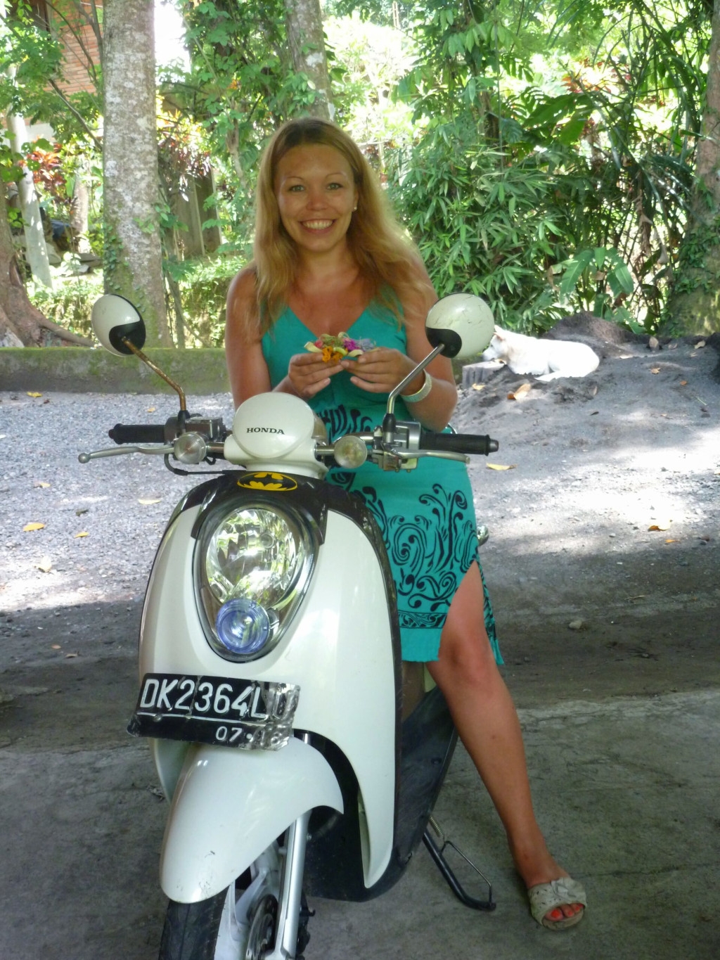 Das Bild zeigt die strahlende Weltenbummlerin und Autorin Susanne auf einem Motorroller auf Bali als Sinnbild dafür, dass Menschen mit chronischen Schmerzen mit der richtigen Vorbereitung lange und weite Reisen genießen können.