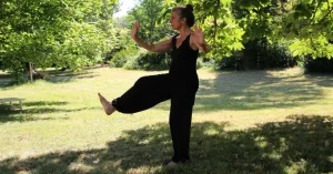 Das Bild zeigt einen älteren Menschen beim QiGong im sonnigen Park als Sinnbild dafür, wie Bewegung und Achtsamkeit zum körperlichen und geistigen Wohlbefinden beitragen können.