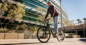 Das Bild zeigt einen älteren Mann auf einem Fahrrad balancieren als Sinnbild für die so häufig angestrebte Longevity, die du durch eine osteopathische Behandlung heute auch online positiv beeinflussen kannst.