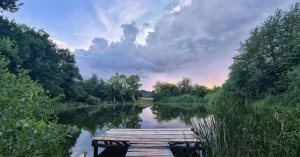 Das Bild zeigt einen Holzsteg an einem schönen ruhigen See im Abendlicht als Sinnbild für den Genuss eines entspannteren Lebens durch das individuell passende Stressmanagement.