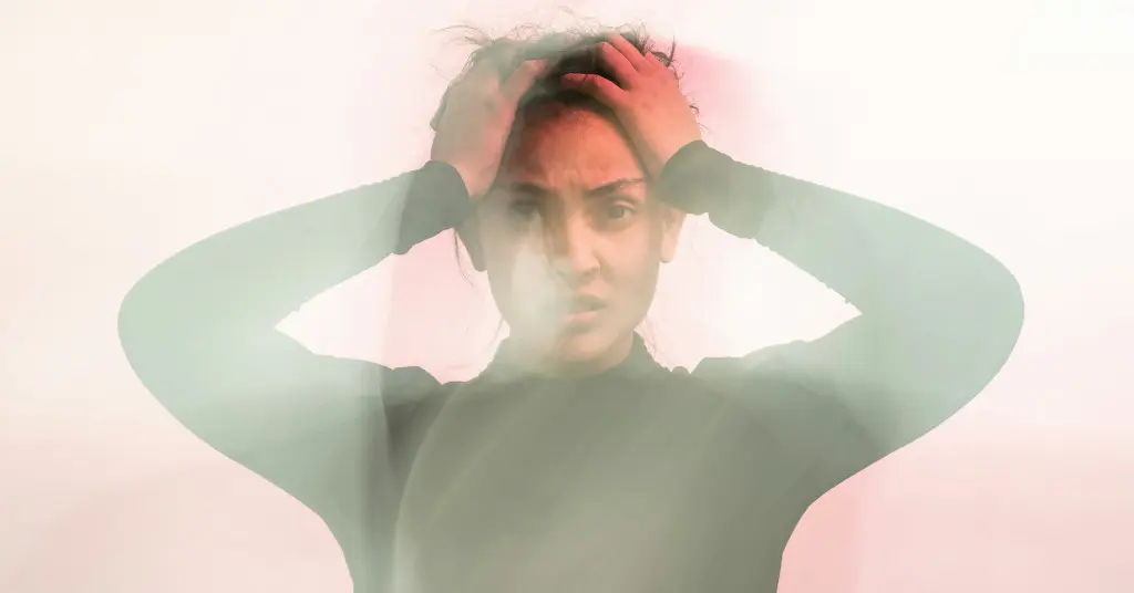 Das Bild zeigt eine gestresste Frau vor einem verschwommenen Hintergrund als Sinnbild dafür, wie ein multidimensionales Coaching zu mehr Gelassenheit und Lebensqualität bei Stress und Ängsten führen kann.