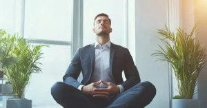 Das Bild zeigt eine erfolgreiche Führungskraft bei der Atementspannung im Büro als Sinnbild dafür, wie du als Leistungsträger:in mit Hilfe kraftvoller Atemrituale Stress abbauen, deinen Darm entlasten und deinen Fokus stärken kannst - mit nur 10 Minuten täglicher Zeit.