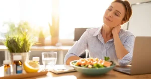 Das Bild zeigt eine Frau an ihrem Küchentisch vor einem gesunden Essen und einem Tablett mit ausgewählten Vitalstoffen als Sinnbild für die Bedeutung von Vitalstoffen für mehr Energie im Alltag.