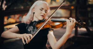 Das Bild zeigt eine entspannte Musikerin beim Instrumentalspiel als Sinnbild dafür, wie dir maßgeschneiderte Physiotherapie helfen kann, deine Beschwerden beim Instrumentalspiel zu behandeln und mühelos zu performen.