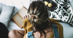 Das Bild zeigt einen entspannten Menschen beim Lesen eines Buches auf dem Bett als Sinnbild dafür, wie dir ein Digital Detox wertvolle Ruhe und Energie zurückbringt.